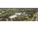 Aerial view of a community center with a pool, golf course, and tennis courts, showcasing amenities at 269 Southampton Dr # 303, Venice, FL 34293