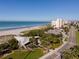 Aerial view of a beachfront with sandy beach, clear skies, and nearby buildings at 269 Southampton Dr # 303, Venice, FL 34293