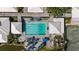 Top-down shot of a serene community pool with umbrellas and lounge chairs surrounded by beautiful landscaping at 269 Southampton Dr # 303, Venice, FL 34293