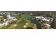 Aerial panorama of a golf course community featuring a lush green landscape with ponds and residential areas at 269 Southampton Dr # 303, Venice, FL 34293