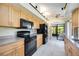 Bright kitchen with black appliances, tile flooring, and view of the lanai at 269 Southampton Dr # 303, Venice, FL 34293