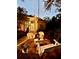 Cozy backyard with a swing, outdoor seating, and charming string lights, perfect for evening relaxation at 271 Manor Rd, Venice, FL 34293