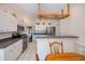 Open kitchen with white cabinets, stainless steel appliances, and eat-in breakfast bar at 271 Manor Rd, Venice, FL 34293