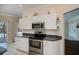 Bright kitchen featuring white cabinets and stainless steel appliances at 271 Manor Rd, Venice, FL 34293