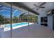 Covered patio with ceiling fan overlooks screened pool and backyard landscaping at 271 Manor Rd, Venice, FL 34293