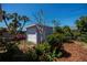 Detached shed in a landscaped backyard with mature trees and tropical plants at 271 Manor Rd, Venice, FL 34293