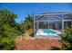 Lush backyard with a screened-in pool and mature landscaping at 271 Manor Rd, Venice, FL 34293