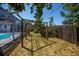 Well-maintained yard with play structure, partial fence, and enclosed pool at 271 Manor Rd, Venice, FL 34293