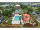 Aerial view of a community pool, cabana, tennis courts, and landscape, surrounded by green foliage at 3006 Caring Way # 304, Port Charlotte, FL 33952