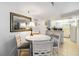 Charming dining area with white table and chairs, mirror decor, and convenient access to the kitchen at 3006 Caring Way # 304, Port Charlotte, FL 33952