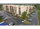 A multi-story condo complex showcasing its architecture, parking, and landscaping from an aerial perspective at 3006 Caring Way # 304, Port Charlotte, FL 33952