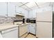 This kitchen features light blue cabinets, laminate countertops, tile backsplash and standard appliances at 3006 Caring Way # 304, Port Charlotte, FL 33952