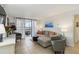 Bright living room features neutral decor, tile flooring, comfortable seating, and sliding glass doors to balcony at 3006 Caring Way # 304, Port Charlotte, FL 33952