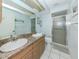 Clean bathroom with double sinks, granite countertops, and a glass-enclosed shower at 3167 Night Heron Ln, Venice, FL 34293