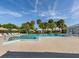 Large community pool with ample lounge chairs and lush tropical landscaping in the background at 3167 Night Heron Ln, Venice, FL 34293