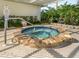 Community hot tub surrounded by lush greenery and a paved seating area at 3167 Night Heron Ln, Venice, FL 34293
