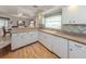 Well-lit kitchen with white cabinetry, tile backsplash, and a view of the dining area at 3167 Night Heron Ln, Venice, FL 34293