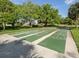 Shuffleboard courts surrounded by mature trees and well-maintained grounds at 3167 Night Heron Ln, Venice, FL 34293