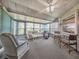 Relaxing sunroom featuring large windows, a ceiling fan, and comfortable seating at 3167 Night Heron Ln, Venice, FL 34293