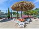 Tennis courts shaded by tropical Tiki hut umbrella and seating area for players at 3167 Night Heron Ln, Venice, FL 34293