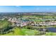 Aerial community view showcasing homes, golf course, lakes, and lush greenery under a blue sky at 3337 Pine Shadow Cir, North Port, FL 34287