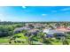 Community aerial view showing well-maintained homes, mature palm trees, landscaping, and golf course at 3337 Pine Shadow Cir, North Port, FL 34287