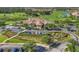 A landscaped roundabout with the clubhouse in the background with cars parked in the parking lot at 3337 Pine Shadow Cir, North Port, FL 34287