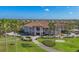 Aerial view of the clubhouse exterior surrounded by a golf course, trees, and parking at 3337 Pine Shadow Cir, North Port, FL 34287