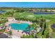 Aerial view of the community pool, surrounded by lush greenery, golf course and lounge chairs at 3337 Pine Shadow Cir, North Port, FL 34287