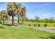 Scenic view of the golf course with mature palm trees lining the fairway and blue sky backdrop at 3337 Pine Shadow Cir, North Port, FL 34287