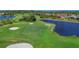 Overhead view of an expansive green golf course, complete with sand traps and a tranquil lake for added challenge at 3337 Pine Shadow Cir, North Port, FL 34287