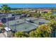 An aerial view showcasing multiple tennis courts surrounded by lush greenery and well-maintained landscaping at 3337 Pine Shadow Cir, North Port, FL 34287