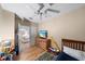 Well-lit bedroom features a ceiling fan, wood floors, and a glimpse into the living area at 414 Laurel Lake Dr # 203, Venice, FL 34292