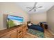 Comfortable bedroom with a large dresser, ceiling fan, and a flat screen TV at 414 Laurel Lake Dr # 203, Venice, FL 34292