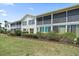 Beautiful exterior view of the condo building with manicured landscaping and screened balconies at 414 Laurel Lake Dr # 203, Venice, FL 34292