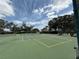 View of the community tennis courts on a sunny day with blue skies and green trees at 414 Laurel Lake Dr # 203, Venice, FL 34292