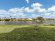 Picturesque backyard with a tranquil pond view and lush green space at 423 Pirates Pt, North Port, FL 34287