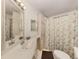 Bright bathroom with a large mirror, ample lighting, and white cabinetry plus a shower at 423 Pirates Pt, North Port, FL 34287