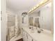 This is a well-lit bathroom with a large mirror and a shower with patterned curtains at 423 Pirates Pt, North Port, FL 34287