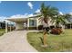 Charming home featuring a covered carport, lush landscaping, and inviting curb appeal at 423 Pirates Pt, North Port, FL 34287