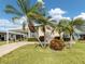 Inviting home with a well-manicured lawn, mature palm trees, and covered carport at 423 Pirates Pt, North Port, FL 34287