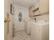 Well-lit laundry room featuring a washer, dryer, storage cabinets and decorative door at 423 Pirates Pt, North Port, FL 34287