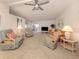 Bright living room with comfortable seating, ample lighting, and a ceiling fan at 423 Pirates Pt, North Port, FL 34287