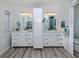 Bathroom featuring double sink, granite countertops, white cabinetry, new fixtures, and updated flooring at 425 Pirates Pt, North Port, FL 34287