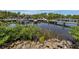 Beautiful view of boat docks with power boats along a serene waterway, framed by lush foliage and rocky landscaping at 425 Pirates Pt, North Port, FL 34287