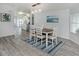 Open concept dining area with sleek grey flooring and room for six under modern pendant lighting at 425 Pirates Pt, North Port, FL 34287