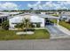 Single-story home featuring mature landscaping, a covered carport, and a well-maintained lawn at 425 Pirates Pt, North Port, FL 34287