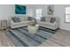Bright living room featuring two sofas, a round coffee table, and wood-style floors at 425 Pirates Pt, North Port, FL 34287