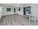 Bright sun room featuring wood look floors, natural light, views, and access to kitchen at 425 Pirates Pt, North Port, FL 34287