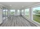 Bright sun room featuring wood look floors, natural light, and exterior views at 425 Pirates Pt, North Port, FL 34287